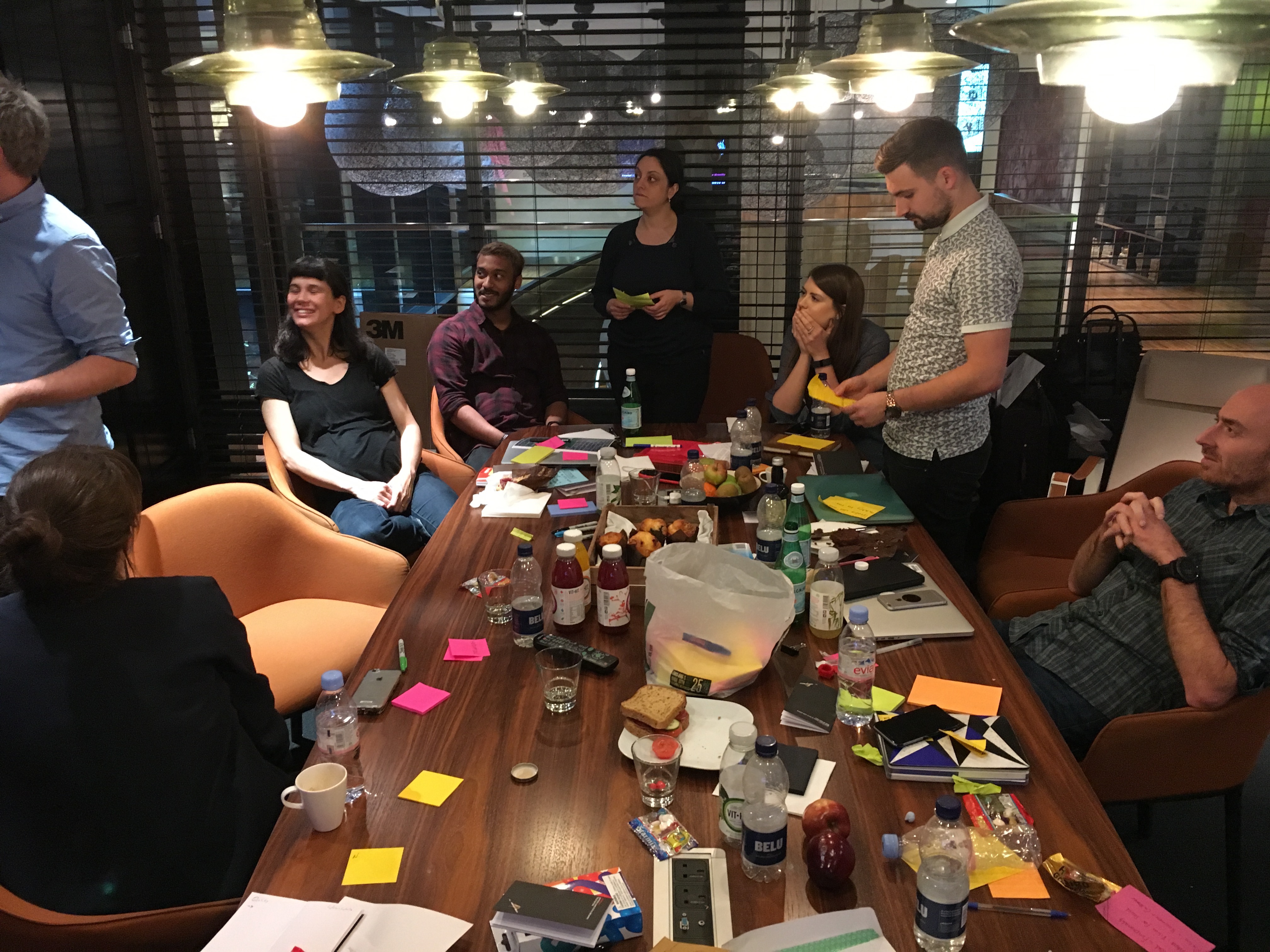 Team ideation workshop around a table of sticky notes